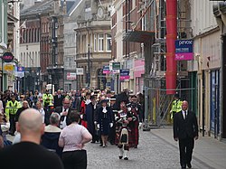 A procession of assorted guests and Hull nobility is lead by a bagpiper for the proclamation of Charles III as King