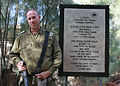 אל"מ ארז לב-רן לצד שלט הנצחה אודות מהלכי חטיבה 8 במהלך מבצע אסף
