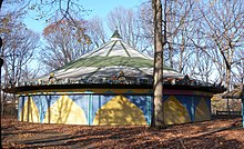 A blue and yellow pavilion surrounded by trees.