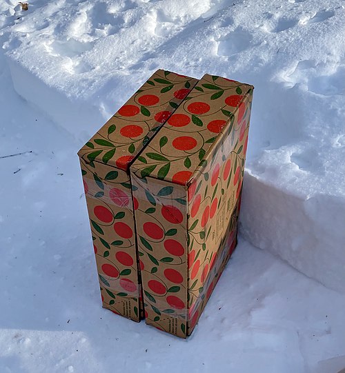 Frozen delivery: Boxes of fresh  oranges and grapefruit delivered at side of street in Winter