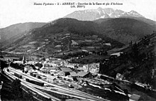 Vecchia cartolina che mostra tutta la stazione, il villaggio e la montagna