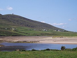 A village at the foot of a mountain, seen across a bay