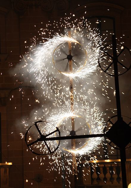 Two ignited Catherine wheels spinning during a traditional Maltese feast