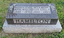 Black granite inscribed with names of Hamilton and his wife, their birth and death years, two roses, and "Until we meet again"