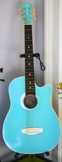 a teal acoustic guitar on a stand