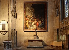 Vue couleur d'une chapelle de style gothique flamboyant, ornée d'un tableau, avec un autel et des fonts baptismaux.