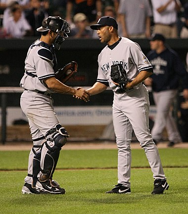 Rivera (right) shakes hands with Jorge Posada after finishing a game in 2009.
