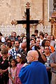 File:Member of a confraternity holding the crucifix while exiting the church.jpg