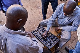 Two men playing Omweso game