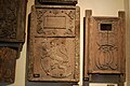 Gamle tremodellar dekorert med relieff av den norske løva og greveleg rangkrona monogram (initialane CCDL) til omnsplater av støypejern laga ved Fritzøe jernverk i Larvik. Frå Fritzøe museum