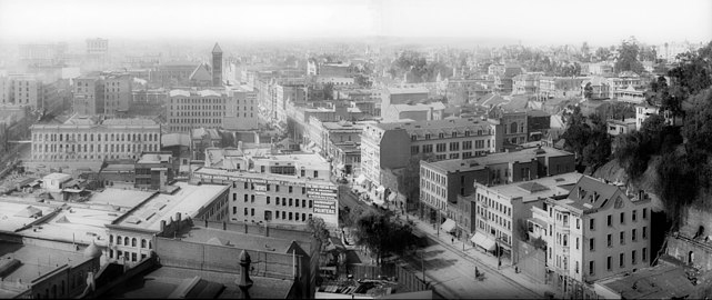 1905 view south on Broadway from north of Temple Street. The Times Mirror printing house in foreground, marked 110 N. Broadway, now site of the Hall of Justice. Towers of the 1888 City Hall on the 200 block of S. Broadway in the distance. Fort Moore Hill, now leveled, at right.