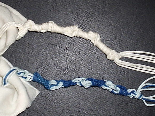 The all-white tzitzit is Ashkenazi. The blue and white tzitzit is knotted in the Sephardi style. Note the difference between the 7-8-11-13 scheme and 