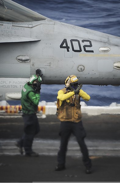 File:U.S. Navy Aviation Boatswain's Mate (Equipment) 3rd Class Meagan Rowland, left, guides an F-A-18C Hornet aircraft assigned to Marine Fighter Attack Squadron (VMFA) 323 onto a catapult as Aviation 131123-N-AZ866-009.jpg