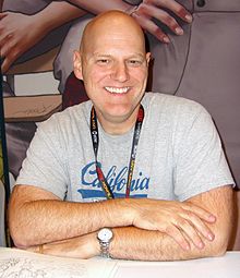 Larsen smiling while seated at a table