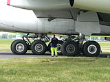 エアバスA380の主脚。中央に立つ人物の右に見えるのが4輪ボギーの主翼主脚、奥に見えるのが6輪ボギーの胴体主脚