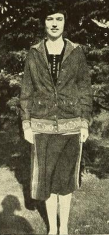 A young white woman, standing outdoors, wearing a casual skirt set