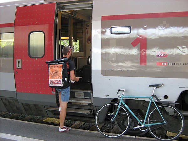 A bicycle courier transferring urgent mail onto a high-speed train in Geneva, Switzerland