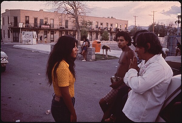 A young woman talking with a group of young men in El Segundo Barrio, El Paso (1971)