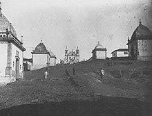 Photographie en noir et blanc de mauvaise qualité représentant la montée du chemin du Calvaire, avec les chapelles tout du long.