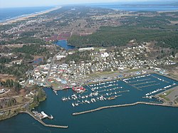 Aerial view of Ilwaco and Ilwaco Harbor. The western edge of Long Beach Peninsula is on the left, and cranberry bogs are visible immediately north of downtown Ilwaco.