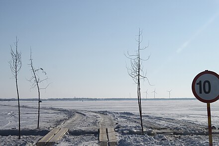 Ice road in Estonia with a "bridge" over a crack marked with young trees. Speed limit 10 km/h