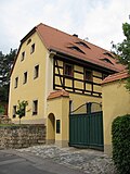 Stable house of a former farm and supporting or courtyard wall