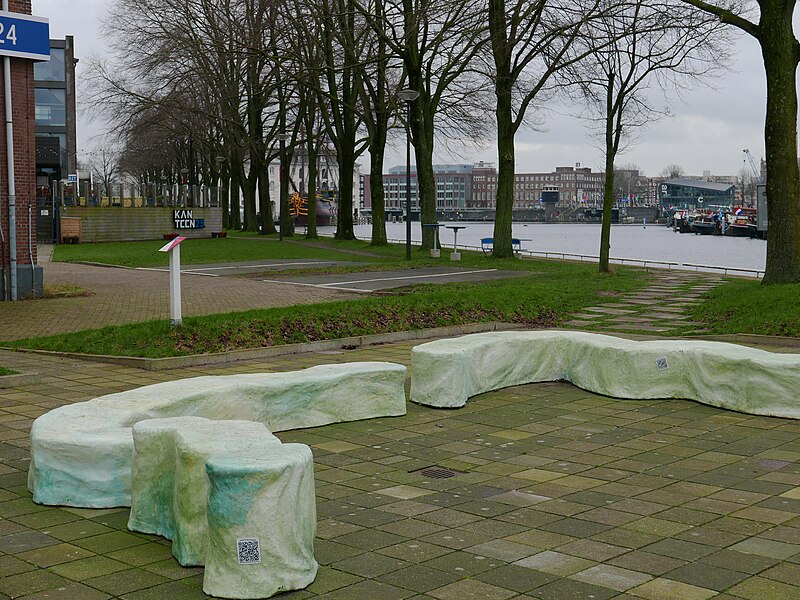 File:Outdoor benches at the area Marineterrein with a view through tree trunks; free photo Amsterdam, Fons Heijnsbroek, 01-2022.jpg