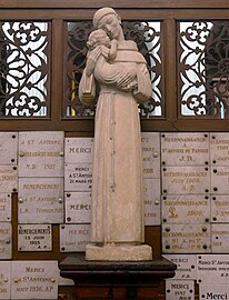 Statue de saint Antoine de Padoue, devant des ex-votos.