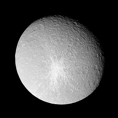 A spherical body is almost fully illuminated. Its grayish surface is covered by numerous circular craters. The terminator is located near the upper-right limb. A large crater can be seen near the limb in the upper-left part of the body. Another smaller bright crater can be seen in the center. It is surrounded by a large bright patch having the shape of a five-pointed star.