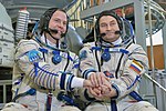 Soyuz MS-08 backup crew in front of the Soyuz spacecraft mockup.jpg