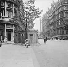 Casemate en brique dans une rue de Londres, avec la colonne Nelson à l'arrière-plan