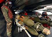 US Navy 050112-N-5345W-074 Aviation Ordnancemen prepare to load 500-pound laser guided bombs (GBU-12) onto weapon pylons under an F-14B Tomcat