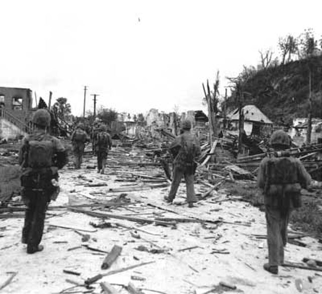 U.S. Marines walk through the ruins of Hagåtña, July 1944.