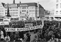 Fotografi av demonstrasjon av forbund av fordrevne, såkalte Landmannsschaft (forbund for landsmenn) i Bonn i 1951. Ingen almisser, bare rettigheter, forteller plakaten.
