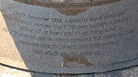 Photo agrandie de la base du monument, avec des inscriptions noires sur fond gris.