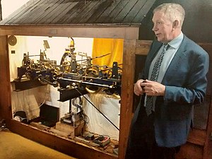 The Trinity College Clock mechanism and the Keeper of the Clock, Dr Hugh Hunt in February 2019 Cmglee Cambridge Trinity clock keeper Hugh Hunt.jpg