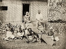 Photograph of a meeting of the Great Council of Chiefs in Waikava in 1876. The Great Council of Chiefs meeting at Waikava was opened by Governor Gordon on 20 November 1876 and lasted nearly 3 weeks. Gordon outlined his plans for indirect rule and established procedures for future meetings. Numerous resolutions were adopted and at the end of the meeting a letter to the British Queen was signed by the principal chiefs. Various people came to the climax of the meeting which included a feast, dancing and a solevu. Senior members of the Great Council of Chiefs with Cakobau seated at the top of the ramp above his brother Ratu Josefa Celua. The chief to his left, wearing a white masi turban is likely Musudroka, the Vunivalu of Rewa. Council of Chiefs, Waikava, 1876.jpg