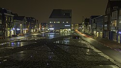 Gezicht over het plein op het gebouw De Bastille van Nijestee bij avond.