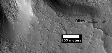 These ridges may be dikes or joints formed as a consequence of a crater impact. As seen by HiRISE under the HiWish program.