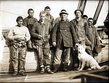 Photo de groupe autour de 1920 prise sur le Maud, navire de Roald Amundsen, avec les explorateurs polaires Gennadij Olonkin (troisième en partant de la gauche) et Oscar Wisting (tenant le chien).