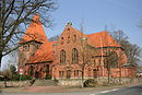 Church with churchyard wall, trees and war memorial