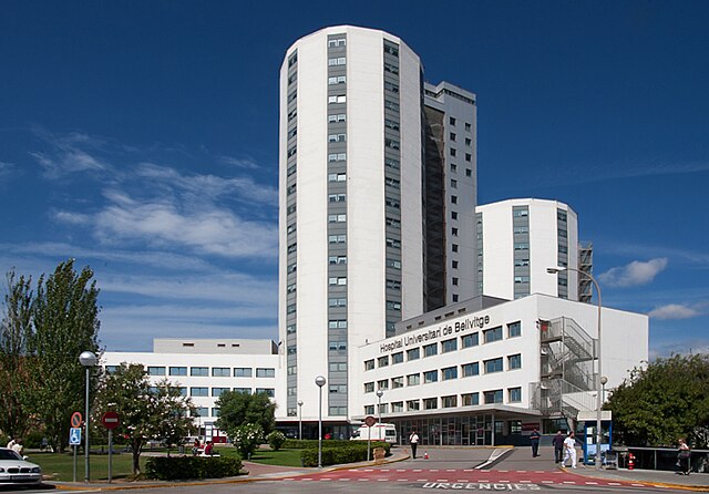 The exterior of Bellvitge University Hospital in L'Hospitalet de Llobregat, Spain, with entrance and parking area for ambulances.