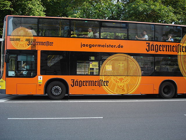 Vinyl decals allowing use of windows, on a side and rear advertisement for alcohol on a Berlin bus