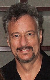 John de Lancie plays the role of the mysterious but powerful alien known as Q. Like many actors in the series, he also worked on some of the video games of the period. John de Lancie Photo-Performance.jpg