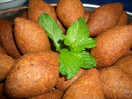A plate of kubbi balls with a garnishing of mint leaves