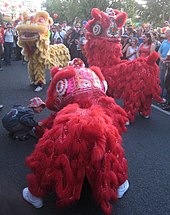Lion dancers wearing bright red and yellow costumes
