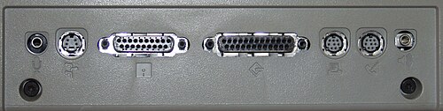 Rear panel showing the ports. From left to right: microphone, ADB, external floppy disk drive, SCSI, printer (serial), modem (serial) and headphones. Two TORX case screws are visible, bottom left and right. MacintoshClassicIIRearPanelPorts.jpg