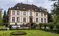 Spätbarockes, zweigeschossiges Herrenhaus mit Walmdach, flankiert von eingeschossigen Wirtschaftsbauten, doppelläufige Treppe, Dreiecksgiebel mit einer großen Parkanlage. Erstmals erwähnt 1341, zerstört im 30 jährigen Krieg. Neu errichtet 1779-83 nach Plänen von Francois Pinot. siehen Landesvermessungsamt Baden-Württemberg (Hrsg.) [1990]: Schlösser, Burgen, Kirchen, Klöster in Baden-Württemberg, (o.O.) 1990