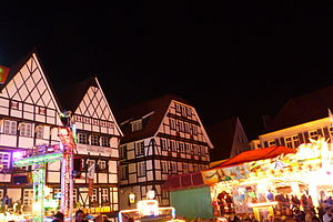 Photo of a market place at night with carrousels and a lot of colourful lights