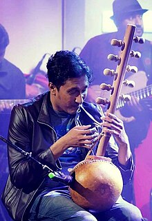 Dinesh Subasinghe Performing a Kora Lute Sri Lankan composer Dinesh Subasinghe playing the kora Lute in Tone Poem program.jpg